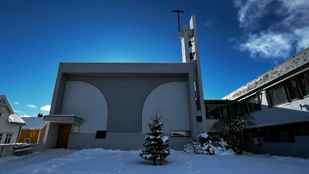 St. Torfinn kirke i Levanger med inngangsparti, klokketårn og kors.